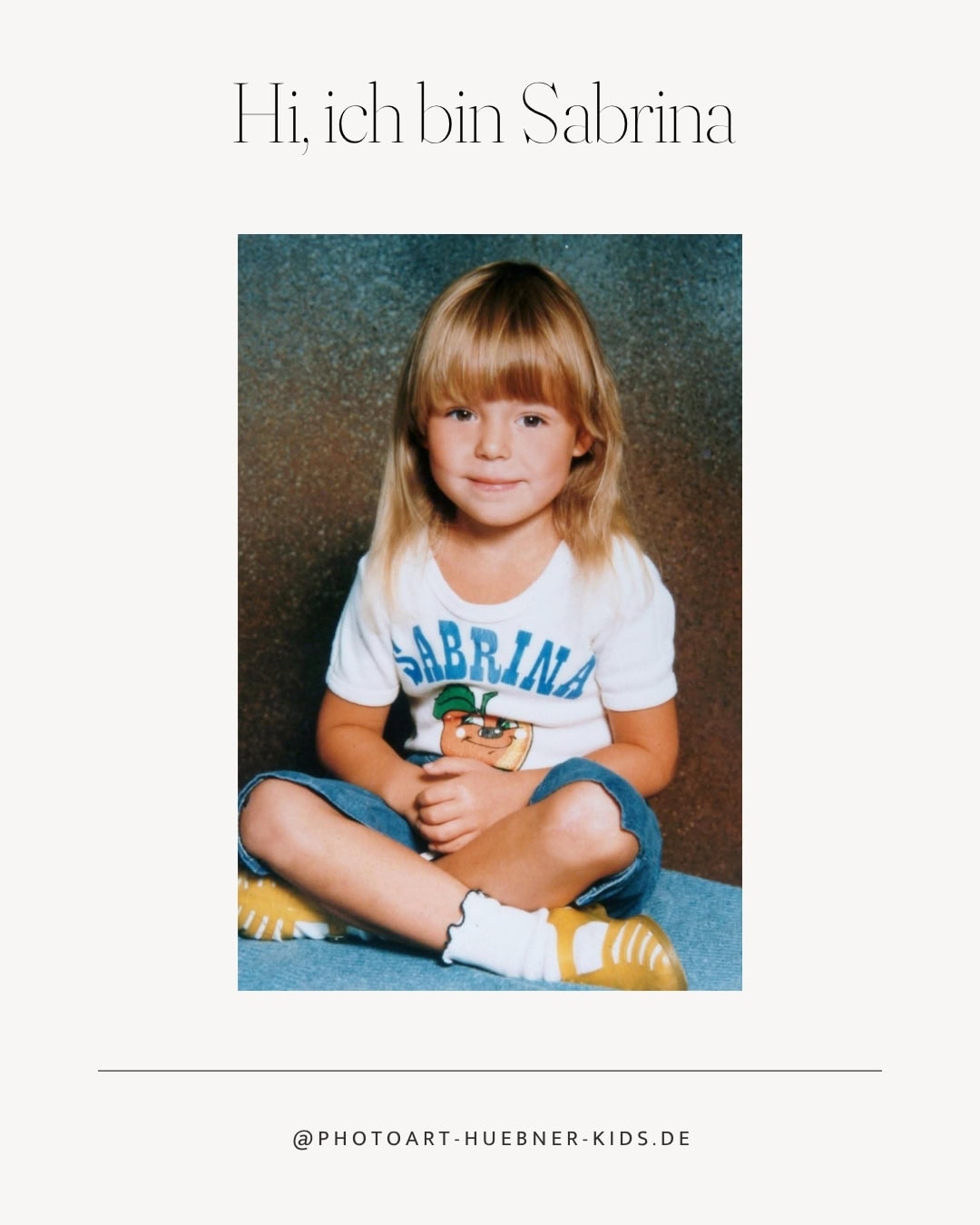 Porträt eines lachenden Mädchens namens Sabrina, sitzend auf dem Boden, in einem weißen T-Shirt mit.